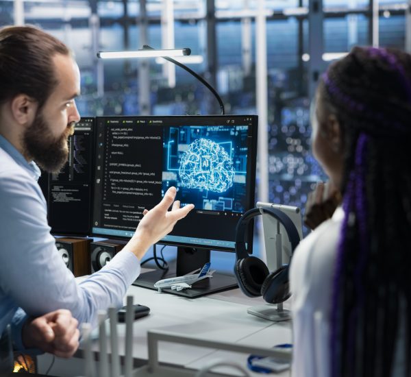 Data center programmers collaborating, working on neural networks AI databases. Server room colleagues talking, using machine learning artificial intelligence on PC to do algorithms improvements